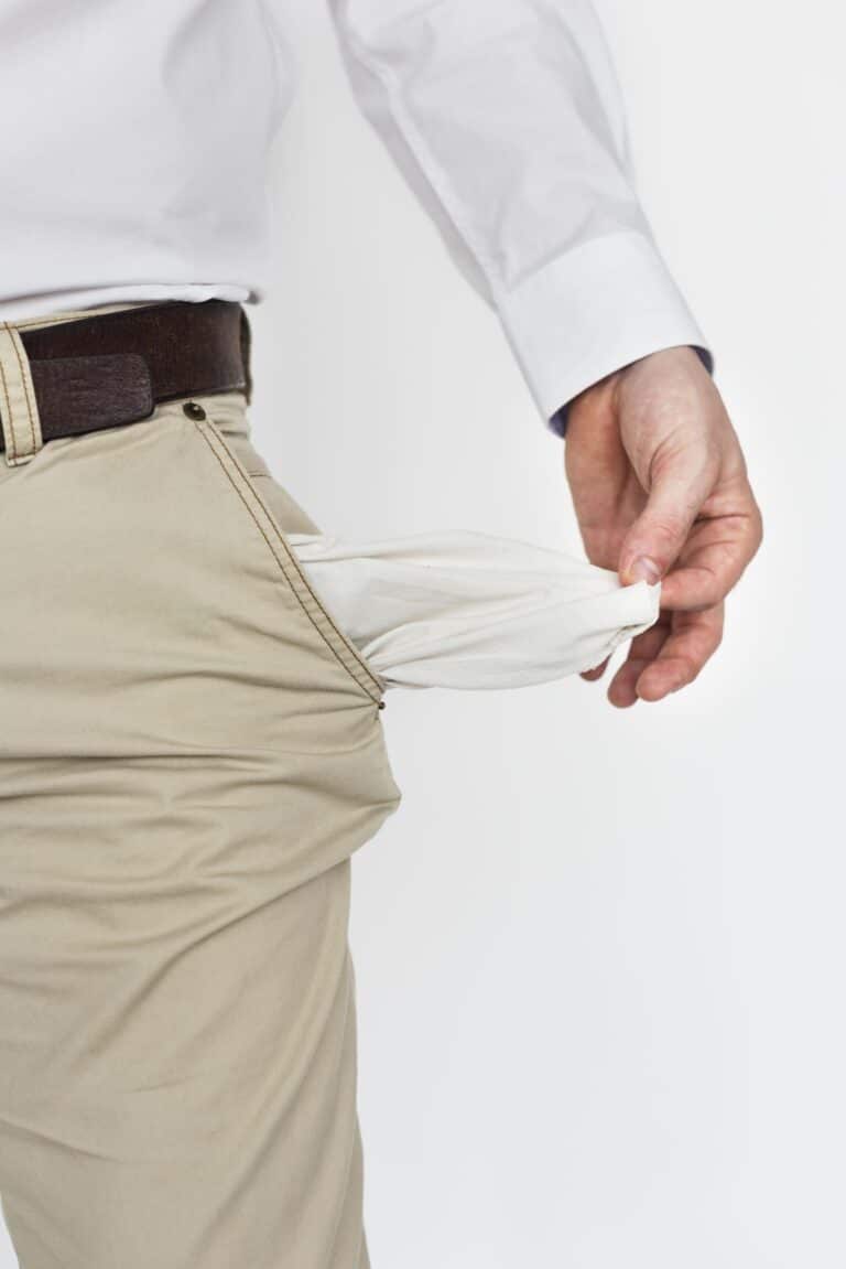 Man pulling out empty pockets symbolizing why skilled online fitness coaches still struggle to make money